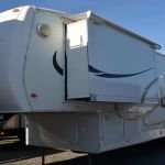 5th Wheel Transportation Services Huge white RV ready to be transported in a 5th Wheel camp
